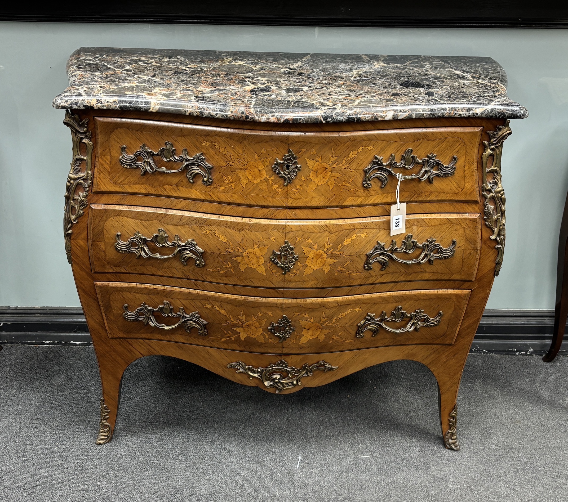 A Louis XVI style gilt metal mounted inlaid kingwood marble topped serpentine bombe commode, width 106cm, depth 49cm, height 89cm